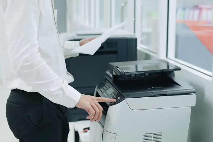 Businessman print documents with the help of office printers on rent in delhi